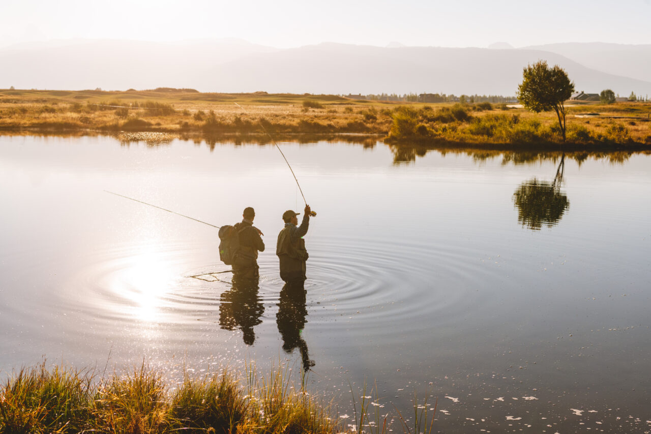 Two anglers fly fishing at sunrise on Tributary water